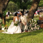 Deux mariés s'embrassent sous un arbre décoré - Un mariage organisé par Les rêves que l'on fête