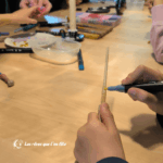 Un enfant décore une baguette magique lors d'une activité à l'école des sorciers